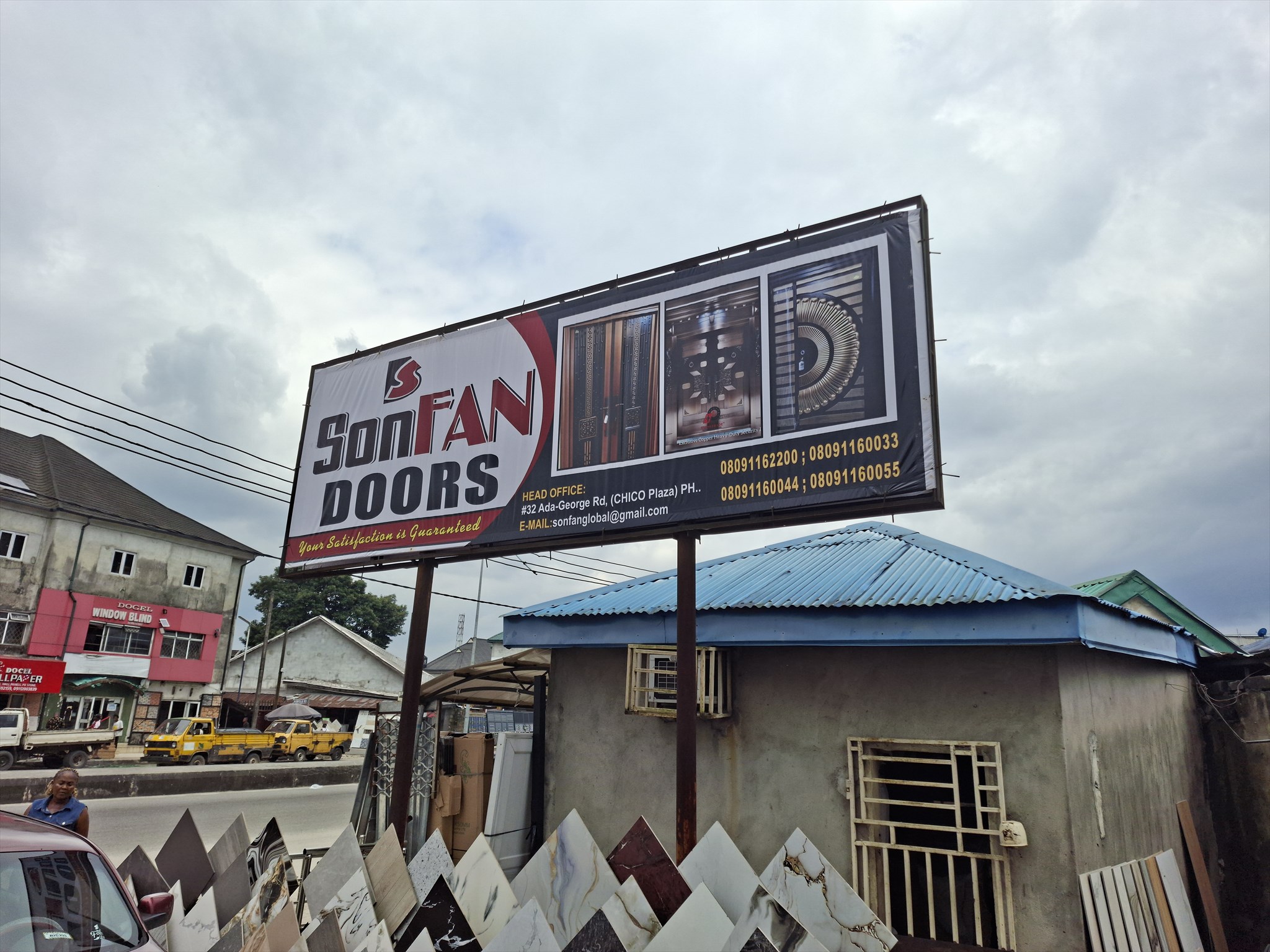 SONFAN GLOBAL DOORS roadside billboard and nearby tile displays